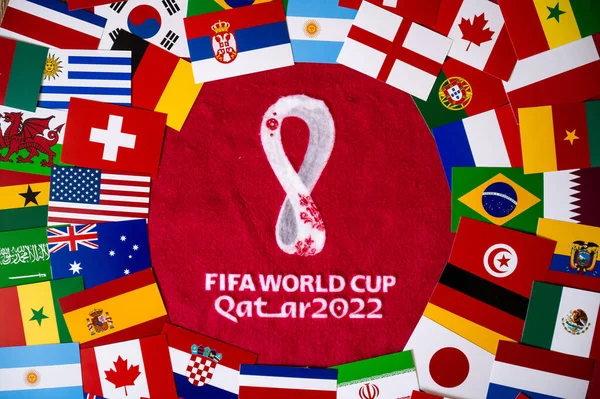 DOHA, QATAR, AUGUST 30, 2022: Flags of all 32 teams participating on FIFA World Cup Qater 2022. Official Logo of Soccer tournament on red background