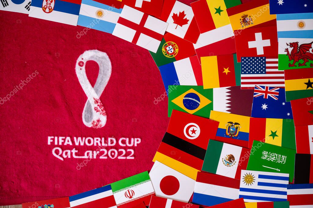DOHA, QATAR, AUGUST 30, 2022: Flags of all 32 teams participating on FIFA World Cup Qater 2022. Official Logo of Soccer tournament on red background