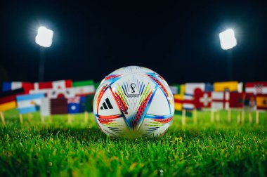 PARIS, FRANCE, 6 Eylül 2022: Adidas Dünya Kupası resmi futbol topu Al Rihla yeşil çimlerin üzerinde. Katar 2022 FIFA Dünya Kupası 'na 32 ülkenin bayrakları katılıyor. Gece stadyumda futbol topu