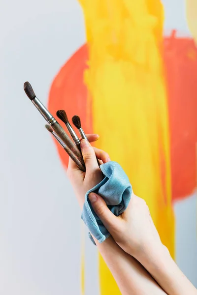 Kadın elleri boya fırçalarını tutuyor. Şövaleye resim yapmak. — Stok fotoğraf
