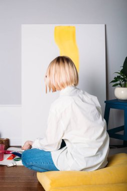 Genç kadın ressam yaratıcı bir stüdyo ortamında resim yapıyor.. 