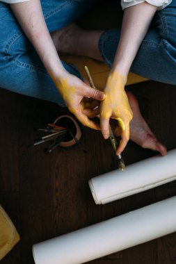 Kadın elleri boya fırçalarını tutuyor. Şövaleye resim yapmak.