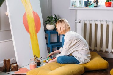 Genç kadın ressam yaratıcı bir stüdyo ortamında resim yapıyor.. 