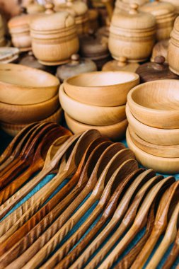 Tezgahta el yapımı ahşap sofra takımı var. Çevre dostu kaşıklar ve tabaklar