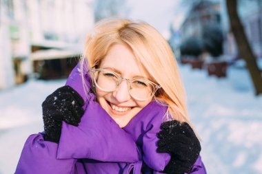 Genç şık sarışın, gözlüklü, karda sokakta.. 