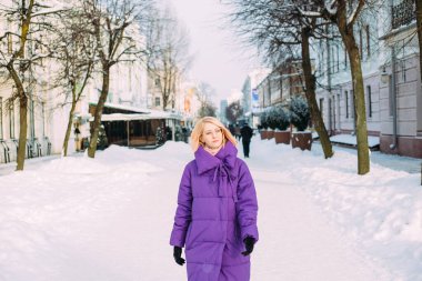 Genç şık sarışın, gözlüklü, karda sokakta.. 