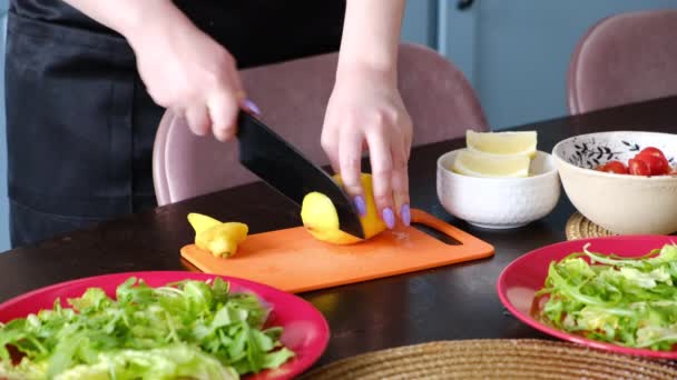 As mãos femininas cortam o limão em partes de carpaccio em uma tábua de corte plástica — Vídeo de Stock