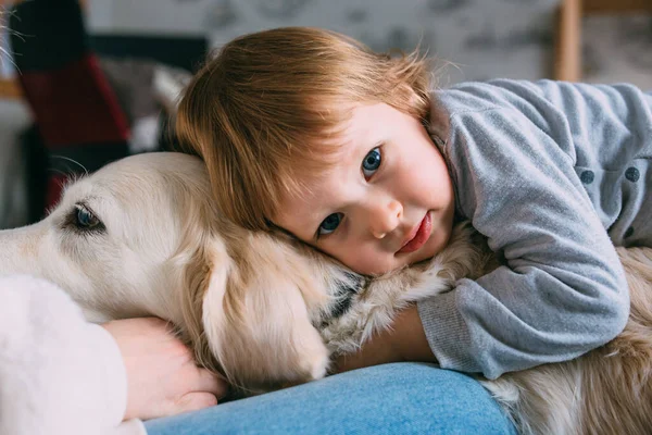 Cute baby and his labrador retriever at home on the bed. — Stock Photo, Image