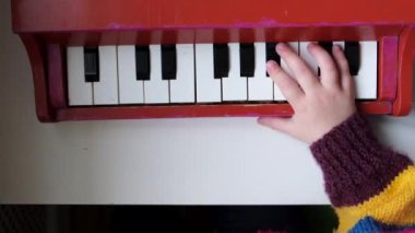  Bir çocuğun küçük elleri çok renkli ahşap bir piyano oyuncağı çalar.
