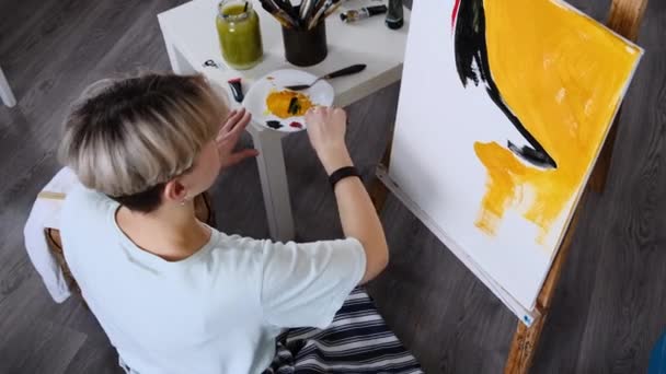 Ung kvinna konstnär målar hemma i en kreativ studio miljö. — Stockvideo