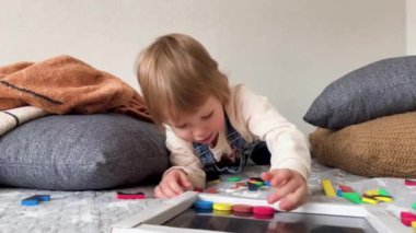 Çocuk evde çok renkli bir manyetik bulmacayla eğitici bir oyun oynuyor