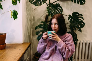 Genç kadın kahve dükkanında kahve içiyor. Kendine zaman ayır..