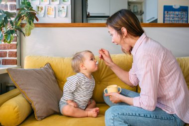 Annem evde küçük bir çocuğu kaşıkla yoğurt ile besler. Aile kavramı