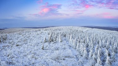 Gün batımında dağlarda kış manzarası, karla kaplı dağ tepeleri ve orman, gözlem kulesinin manzarası..
