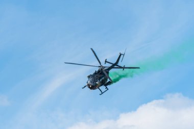 Leszno, Polonya - 17 Haziran 2022: Antidotum Airshow Leszno, Bolkov Bo-105 hafif çift motorlu çok rollü helikopter. Helikopter pilotu uçağın arkasında yeşil duman bırakarak geliyor..
