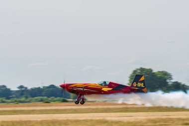 Leszno, Polonya - 17 Haziran 2022: Extra 330SC uçağıyla Antidotum Airshow Leszno, Marek Choim. Pilot, uçağın arkasında muhteşem bir duman bırakarak havaalanı üzerinde alçaktan uçuyor..