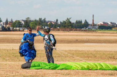 Leszno, Polonya - 17 Haziran 2022: Antidotum Airshow Leszno. Sky Magic paraşüt grubu, başarılı bir gösteriden ve güvenli bir inişten sonra atlayıcılar birbirlerini kutluyorlar..