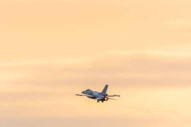 Leszno, Polonya - 17 Haziran 2022: Antidotum Airshow Leszno, F-16 Tiger Demo Team, jet uçağı. Pilot, gün batımında havada muhteşem manevralar yaparak uçağı havada sunar..