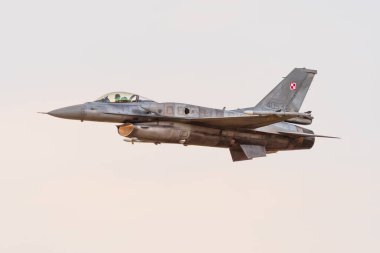 Leszno, Polonya - 17 Haziran 2022: Antidotum Airshow Leszno, F-16 Tiger Demo Team, jet uçağı. Pilot, gün batımında havada muhteşem manevralar yaparak uçağı havada sunar..