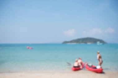 Yazın tropikal plajda, denizde ve mavi gökyüzünde arka plan için bulanık Kafkas insanları aktivitesi