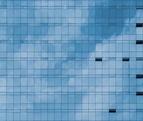 Front view of sky and cloud reflection on modern office building glass wall and windows in the city business area in Korea, monochrome black and white, useful for business background.