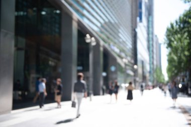 Şehir merkezindeki iş alanındaki modern mağazanın önündeki kaldırımda yürüyen kalabalık, iş dünyası ve şehir manzarası için soyut bulanık insanlar.