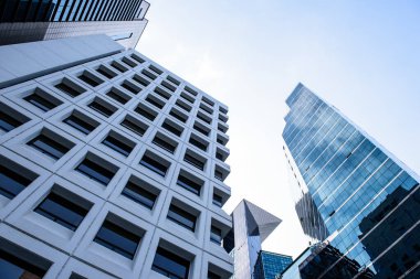 Şehirdeki modern ofis binaları mavi cam pencereli ve cam duvarlı diğer binaları yansıtıyor.