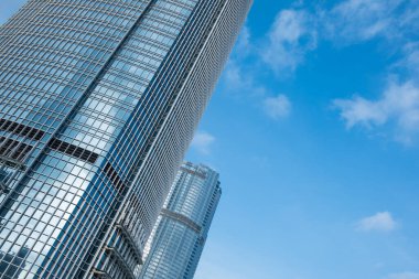 Hong Kong 'daki iş alanı ve mavi gökyüzü çevresindeki binanın mimari ve cam pencereli alçak açılı gökdeleni