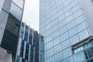 Mavi cam pencereli modern ofis binası. Şehirdeki finans binası iş geçmişi, cephe manzarası olarak