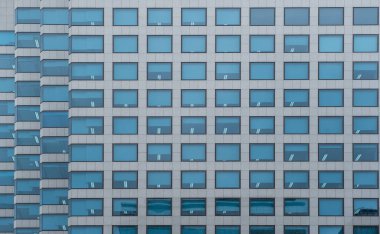 Modern office building with facade of blue glass window. Financial building in the city as pattern background, front view