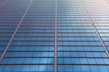 Yeşil cam pencereli modern ofis binası. Kentte fon oluşturma, düşük açı görünümü, renk filtresi etkisi, perspektif