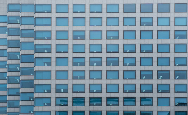 Modern office building with facade of blue glass window. Financial building in the city as pattern background, front view