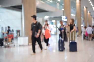 Blurred group of people, crowd, traveler, tourists with baggages walking in airport corridor, holiday weekend travel for background, perspective view, motion blur