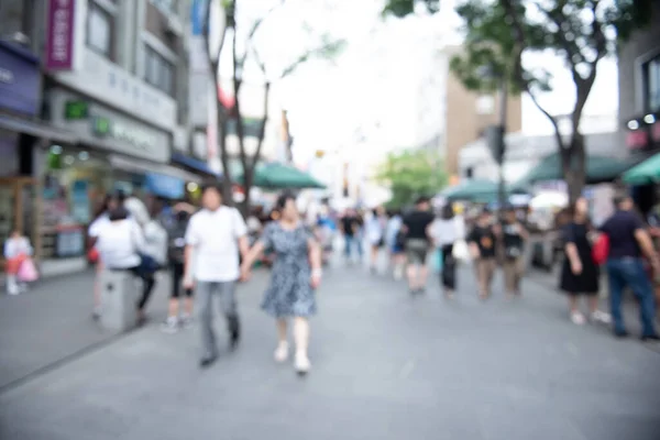 Blurred background, people walking for shopping at outdoor street market, business area in the city. Crowd street in Korea
