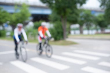 Parktaki bisiklet sokağında bisiklet süren bulanık insanlar, dışarıda egzersiz, sağlıklı yaşam tarzı.