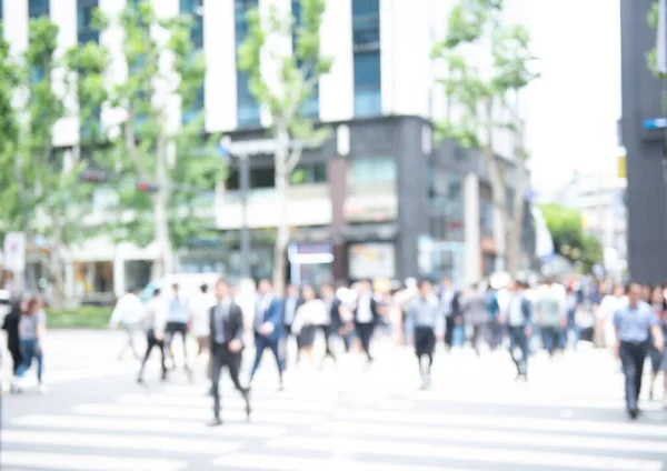 Blurred background of crowd anonymous people walking  on pedestrian and  waiting for traffic light and crossing the street on zebra crossing in the city, business center, Seoul, Korea