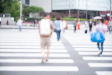 Blurred background of crowd people crossing the road in front of shopping center in the city, urban scene, Seoul, Korea