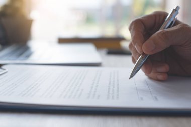 İş adamı ofis masasında dizüstü bilgisayarla resmi sözleşme imzalıyor. İş anlaşması, anlaşma konsepti. Kapat.