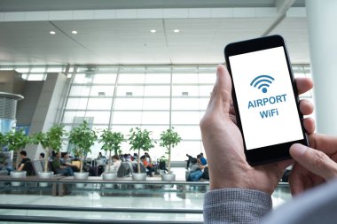Man using mobile smart mobile phone connecting airport free wifi, passengers waiting for boarding pass in airport lounge, free WiFi zone