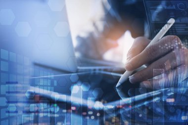 İş analizi ve modern teknoloji konsepti. Ofiste çalışan bir finans analisti. Çift pozlama, dijital tablet kullanan birden fazla iş adamı, dizüstü bilgisayar ve şehir üzerinde çalışıyor, mali grafik, bilgisayar gösterge arayüzü