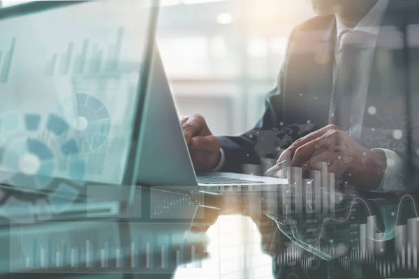 Business analysis and modern technology concept. Businessman, teamwork analyzing monitoring business data on laptop computer at office, modern computer dashboard, stock market report on virtual screen