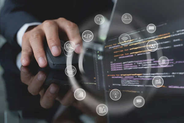 Software developer coding computer program with augmented reality dashboard, app or web design with internet  icons on VR screen. Man hand clicking wireless  mouse, IoT Internet of Things concept
