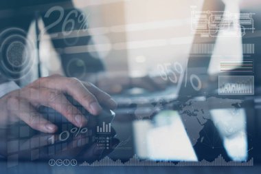 Business analysis, smart office concept, businessman hand clicking wireless mouse working with laptop computer in modern office with financial report diagram on virtual screen, close up