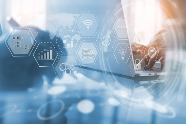 Business Intelligence, IoT Technology, Enterprise Resource Planning ERP concept. Businessman working on laptop computer in modern office with digital icons flow on virtual screen