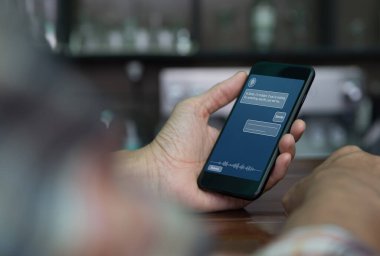 Casual man using mobile smart phone with chatbot application on screen in coffee shop, chat bot artificial intelligence, Ai  concept