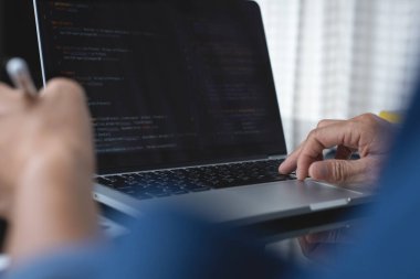 Web or application development, business and technology concept. Programmer, man software developer hands coding HTML, programming Javascript on laptop computer screen, back view close up