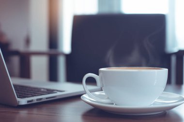 İş yeri, modern yaşam tarzı konsepti. Bir fincan kahve ve ahşap masada açık dizüstü bilgisayar, kahvecide çalışan iş adamı arka plan olarak çalışma alanı, kapanış, klasik ton