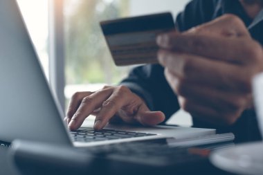 Man online shopping and internet banking on laptop computer by credit card payment, online banking, e commerce, e business, omnichannel or multichannel concept