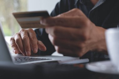 Man online shopping and internet banking on laptop computer by credit card payment, online banking, e commerce, e business, omnichannel or multichannel concept