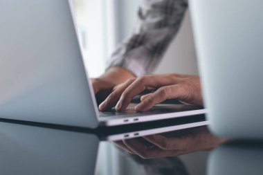 Business man hands typing on laptop computer keyboard at modern office, work process concept, close up, toned image
